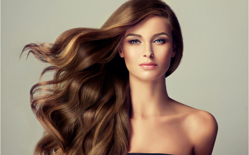 Image of a gal wearing wavy feathered hair that's blowing in a studio