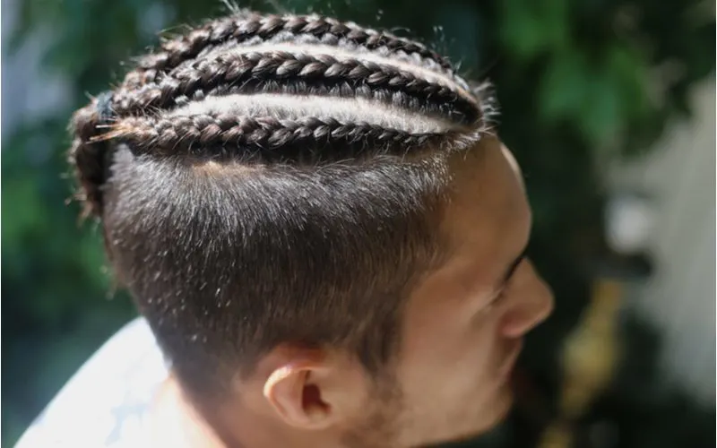 Man with cornrow braids for men in a side-profile image looking to his left