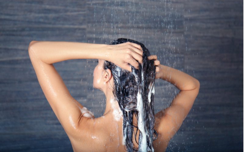 Hình ảnh cho một phần về cách loại bỏ tóc nhờn với một người phụ nữ đang tắm gội đầu trong phòng tắm