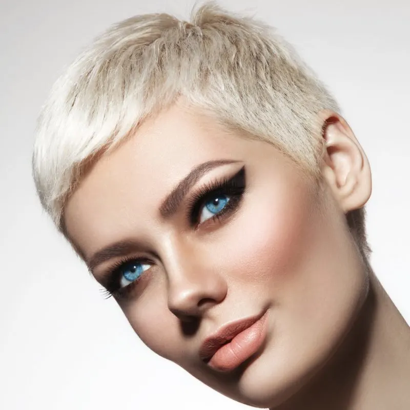 Piece on short pixie feathered hair on a blonde tilting her head to the side