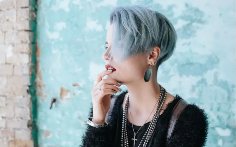 Smoke Stack punk hairstyle worn by a woman in many necklaces in a black furry sweater