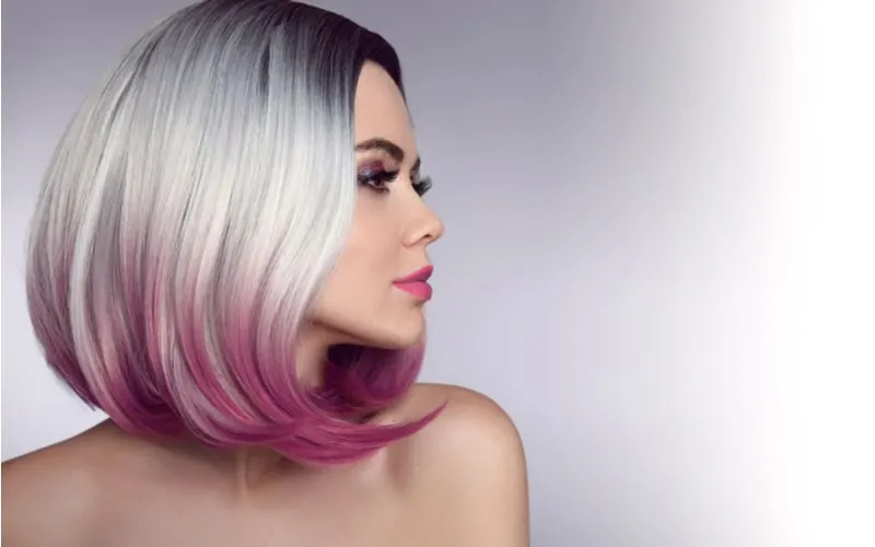 Two tone hair idea we titled Flip the Ombré Script on a woman with platinum silver hair with dark pink ends
