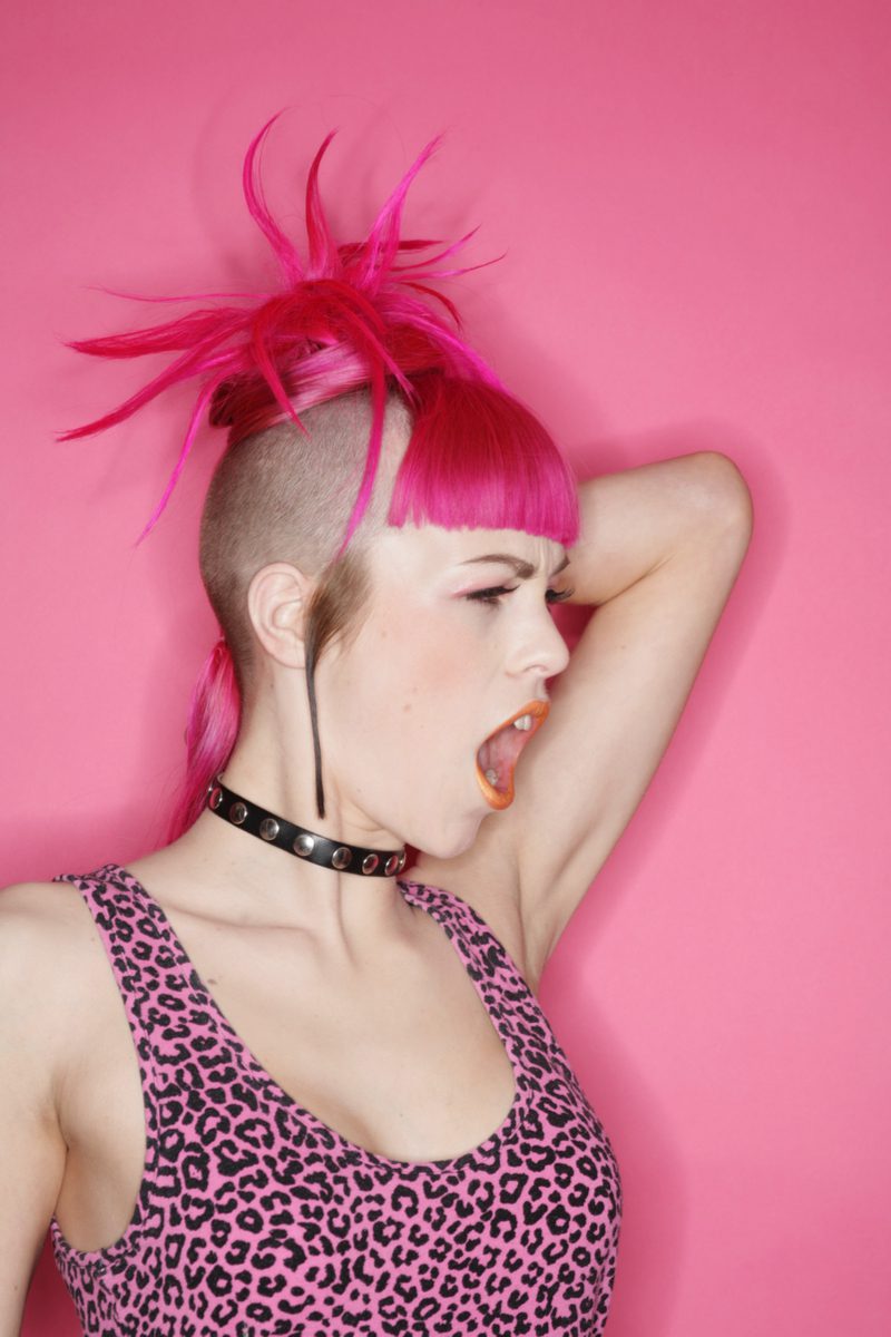 Fuschia Fringe punk hairstyle worn by a woman in a pink cheetah print shirt