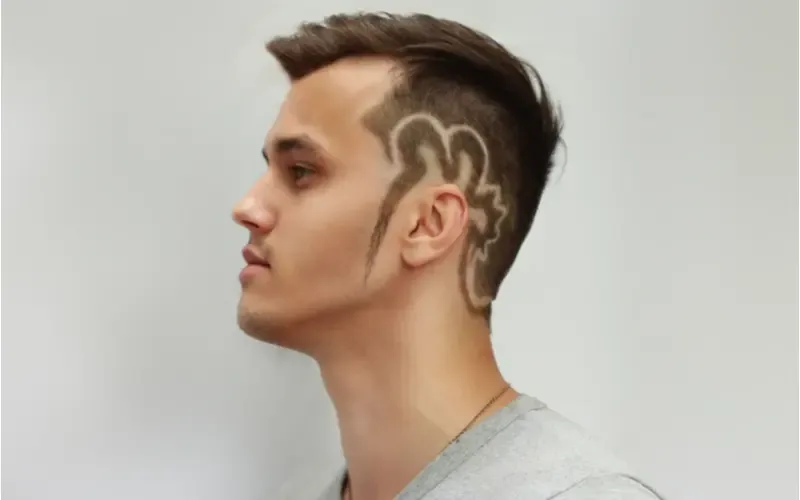 Mohawk Fade With Shaved Designs in a side profile image for a piece on popular haircuts for men