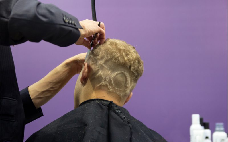 Man with a unique hairstyle pattern gets the top of his head trimmed up