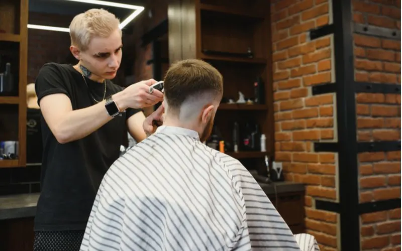 Mohawk Bald Drop Fade being cut by a barber with bleached blonde hair