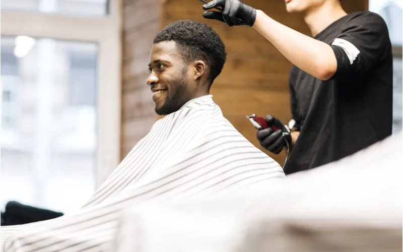 Wide-top mullet with fade on a black man in a barber's chair