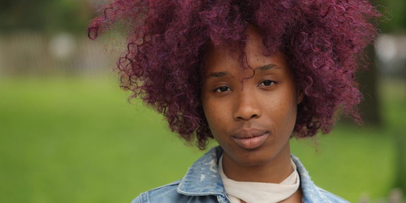 A funky hair color for brown skin featuring plum hair dye