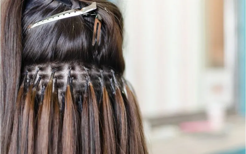For a piece on what is virgin hair, a woman with microbead hair extensions sits in a salon