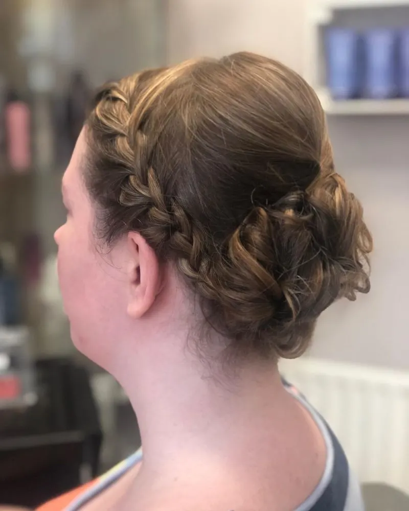 Wedding guest hairstyle with a braided side and an updo in the back
