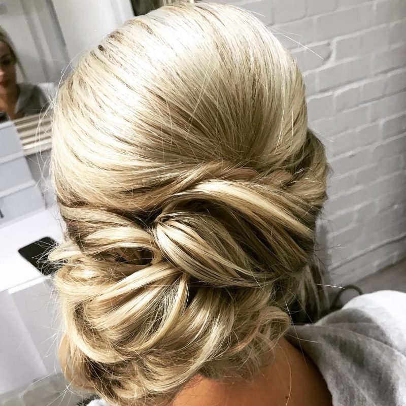 Side Bun wedding guest hairstyle on a woman with blonde hair