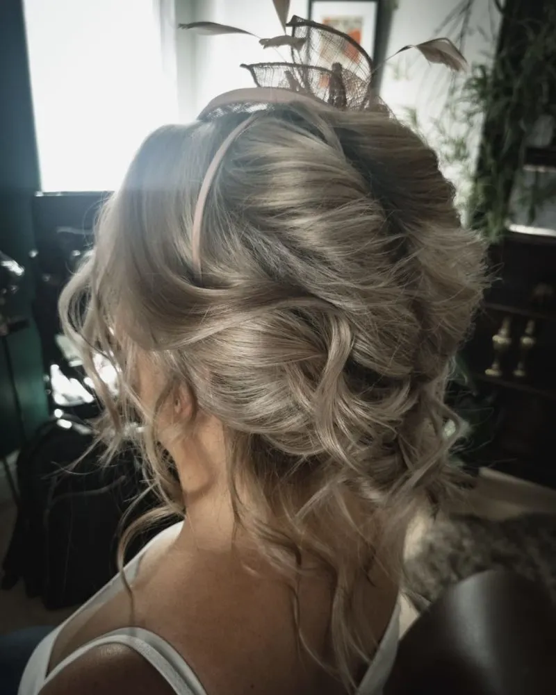 Loose Twisted Bun featured as a wedding guest hairstyle on a blonde woman in a low-cut white cami