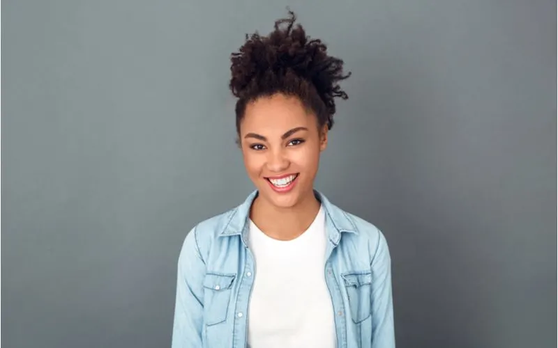 High Puff Ponytail on a woman wearing a jean jacket and a white shirt for a piece on medium to long hairstyles