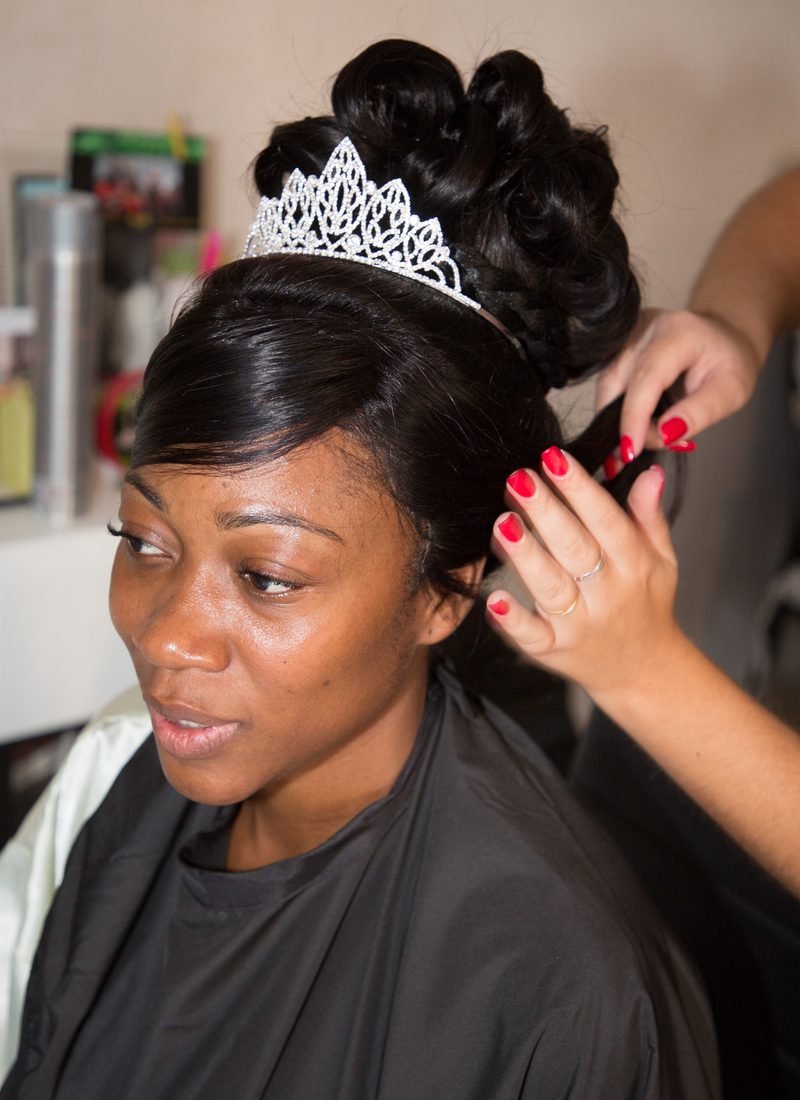 Crowned Bridal Bun With Side-Swept Bangs as a featured African American bride hairstyle