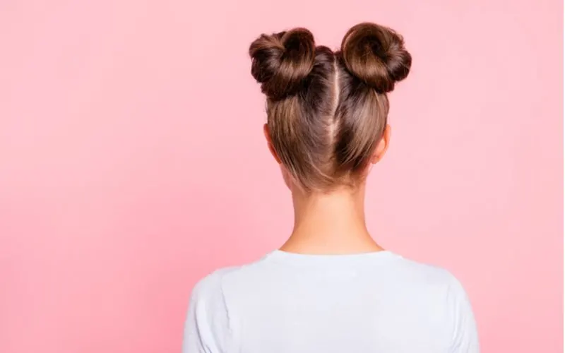 High Space Buns on a woman in a pink room as an idea for an easy hairstyle