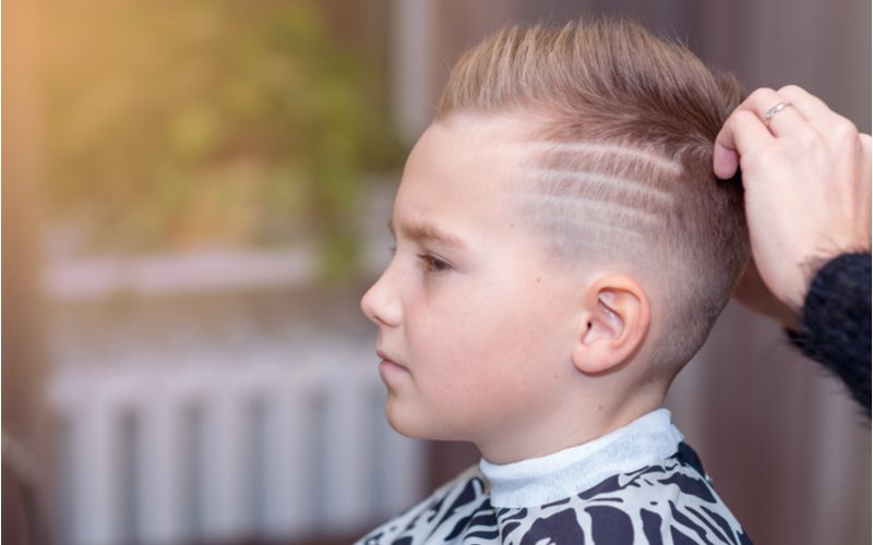 Little boy haircut titled Comb Over Fade With Shaved Lines