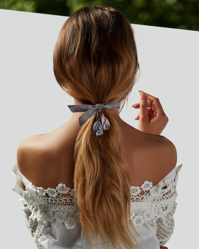 Low Ribbon-Tied Ponytail on a woman in a frilly lace dress with a Dorothy-style aura