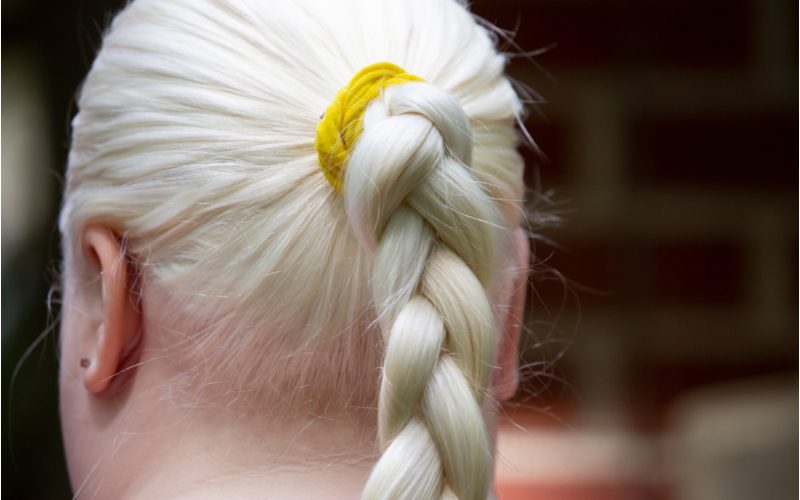 Woman wearing a 3 strand braid in her blonde hair for a piece on heatless curls