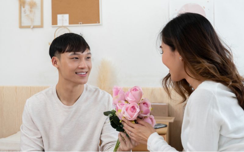 Side-Swept Mushroom Crop haircut on a guy in a white shirt delivering flowers to his girlfriend