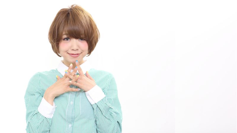 Long Tapered Mushroom Bob Haircut on a gal in a white and green vertical striped button-up shirt holding her fingers to her chin