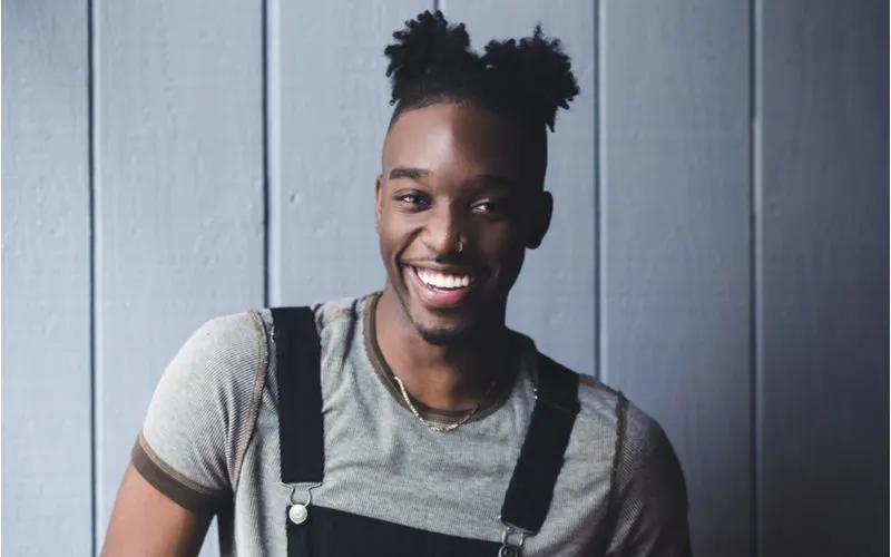 Double Puff Man Buns on a guy in overalls and a gray shirt