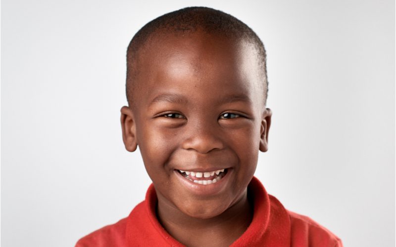 High Bald Fade as a little boy haircut on a black boy in a red polo shirt