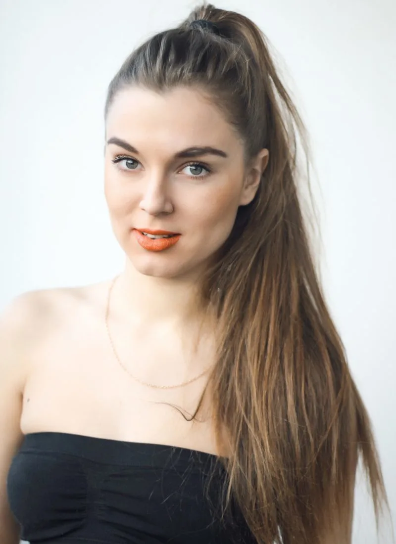 High ponytail on a girl in a black strapless dress with fair skin and brown hair
