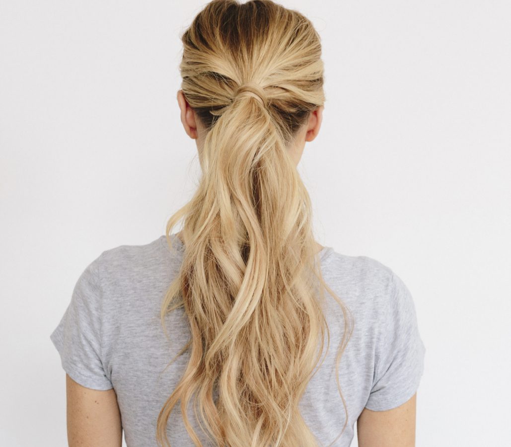 Messy Ponytail With Air-Dried Waves as an easy everyday hairstyle on a blonde woman in a grey shirt