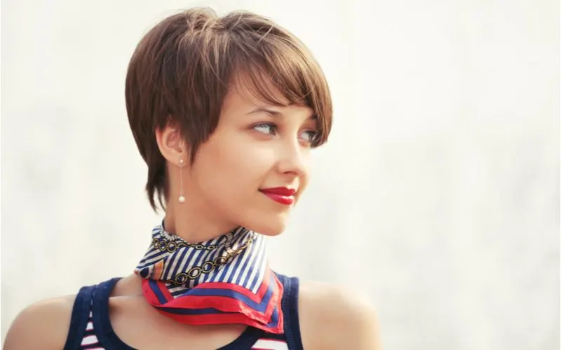 For a piece titled Haircuts for Round Faces Women, a Voluminous Pixie Bob With Side-Swept Bangs is pictured