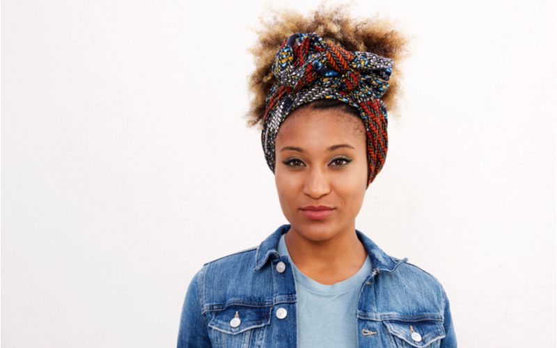 Tied Scarf Updo (an easy hairstyle) on an African-American woman in a jean jacket in a white room