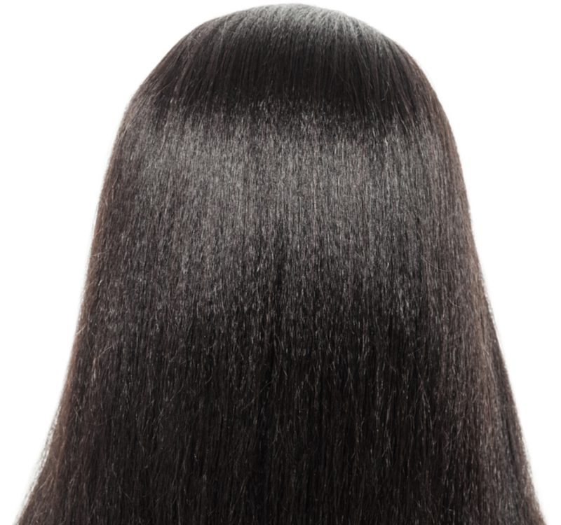 Image for a piece on wigs for black women featuring a rear image of a girl with straight hair in a white studio