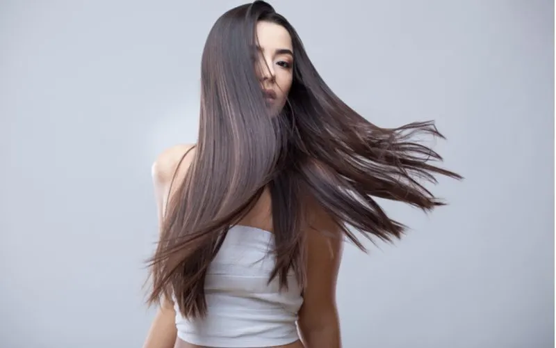 Woman who used Argan oil for hair letting her shiny locks blow in the wind
