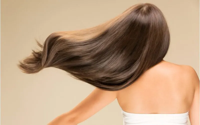 Woman who has used Tea Tree Oil Shampoo on her hair with shiny, long locks