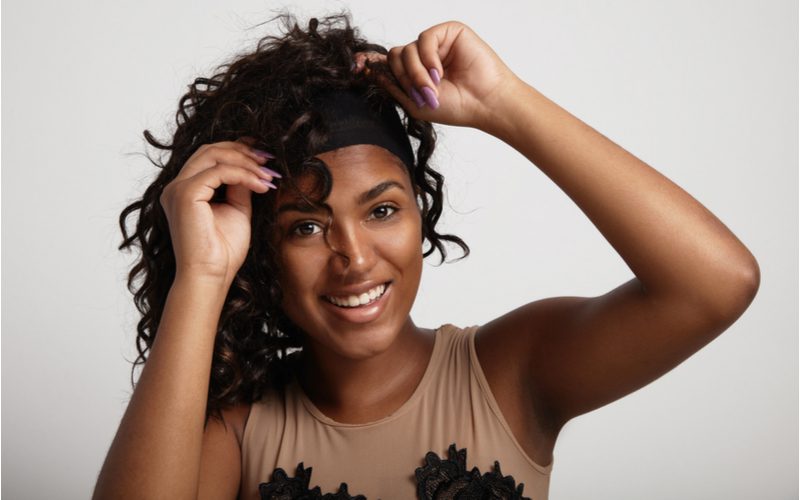 Black woman putting on the best human hair wig for African American Women
