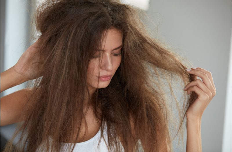 Woman looking like a hot mess express wondering how to fix damaged hair