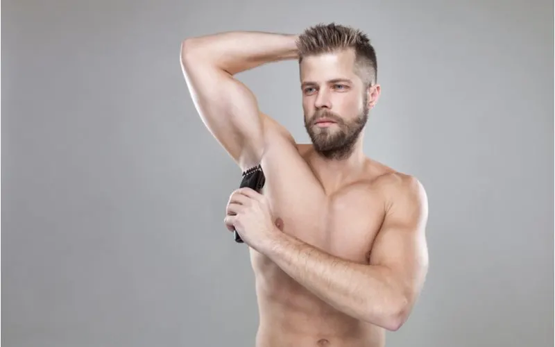 Guy using the best body trimmer for men on his armpits