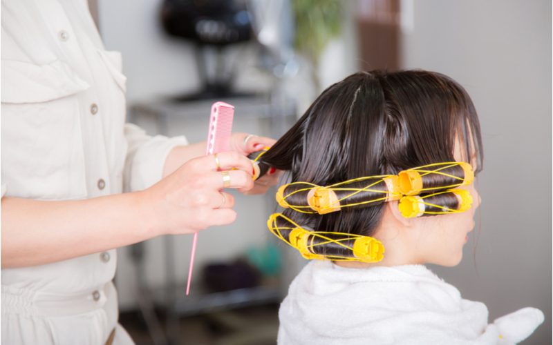 Woman getting one of the popular types of perms in her hair with rollers