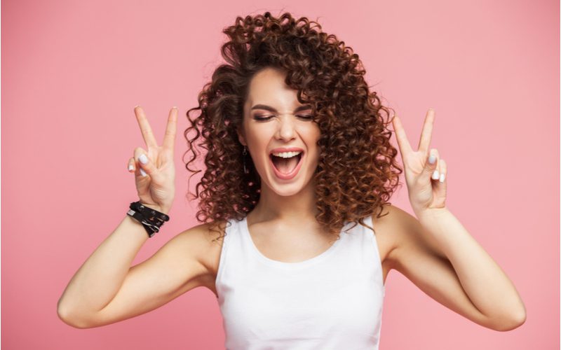 Woman showing us how to activate curls by giving us twin peace signs