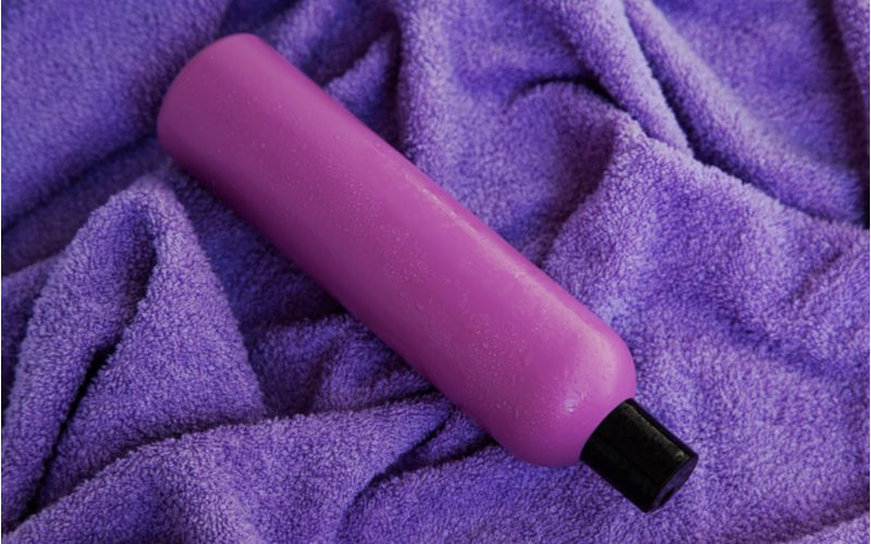 Bottle of purple shampoo on a purple towel