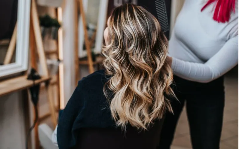 Woman in a salon learning how to keep highlighted hair healthy