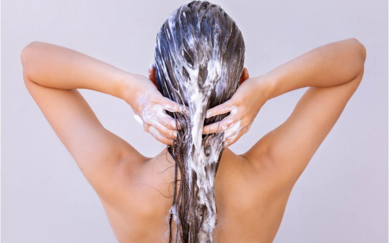 Woman with long hair using the best shampoo for long hair in the shower