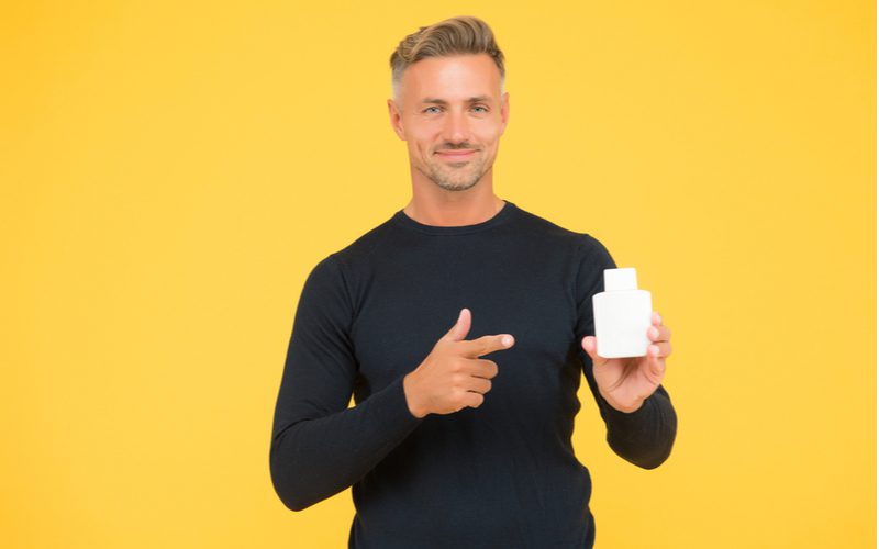 Man holding a a product considered to be one of the best shampoos for oily haired men
