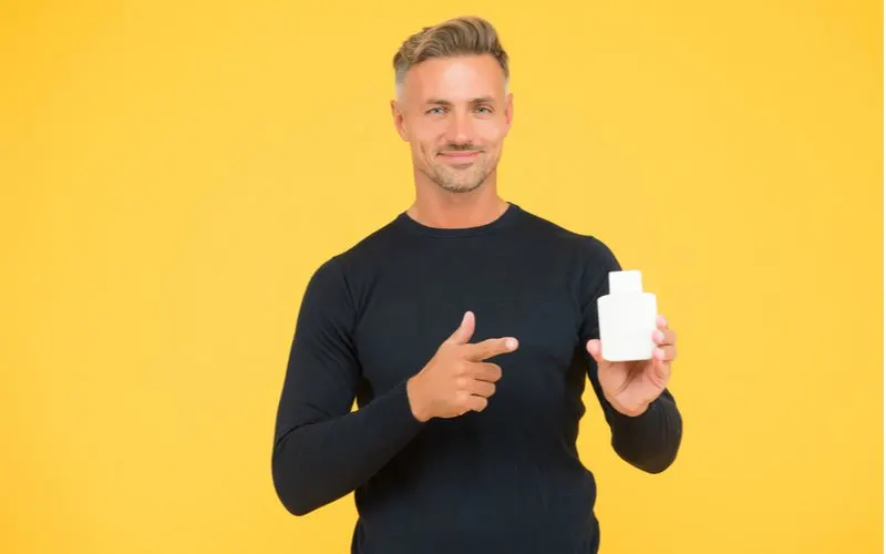Man holding a a product considered to be one of the best shampoos for oily haired men