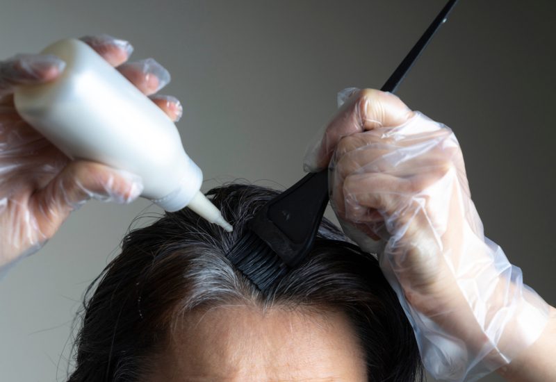 Woman using demi-permanent hair color on her roots
