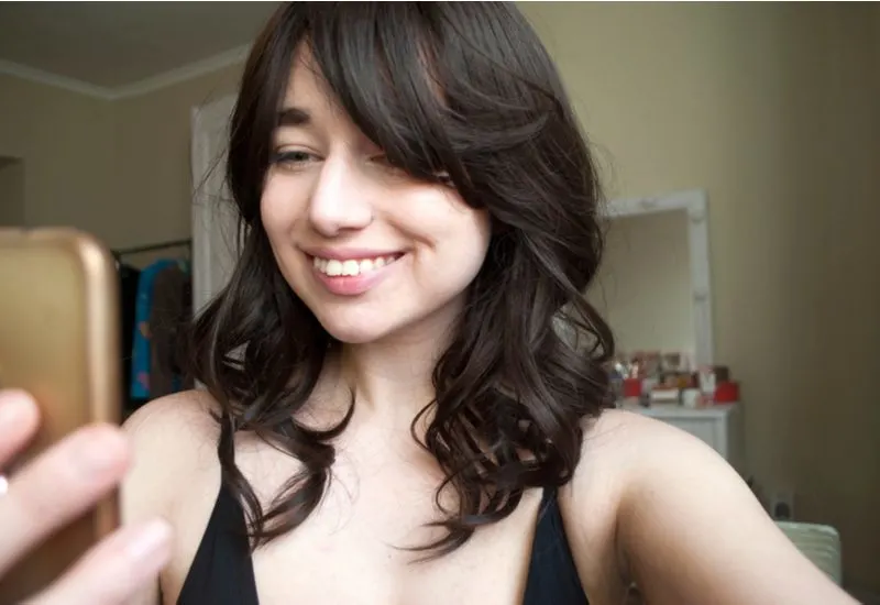 Medium Wavy Curtain Bangs on a brunette woman in a halter top