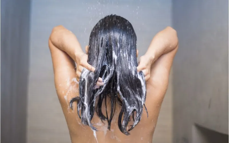 Woman using color depositing conditioner on her hair
