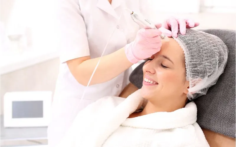 Woman having a microneedling for hair loss treatment in a salon