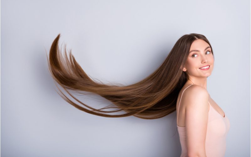 Woman with healthy hair lets it blow in the wind in a studio