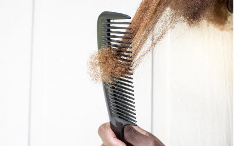 Woman who needs to take the hair porosity quiz running a comb through her thick hair