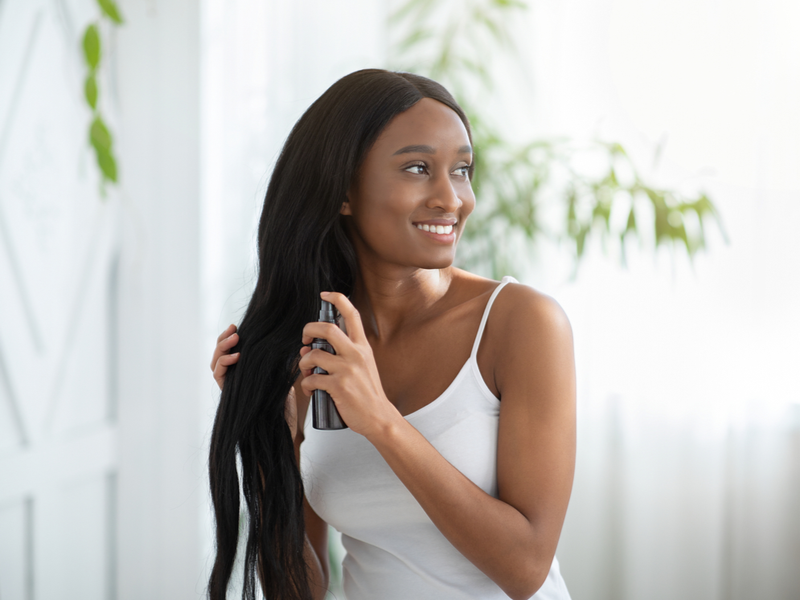 Woman caring for her long relaxed hair with hair moisturizer